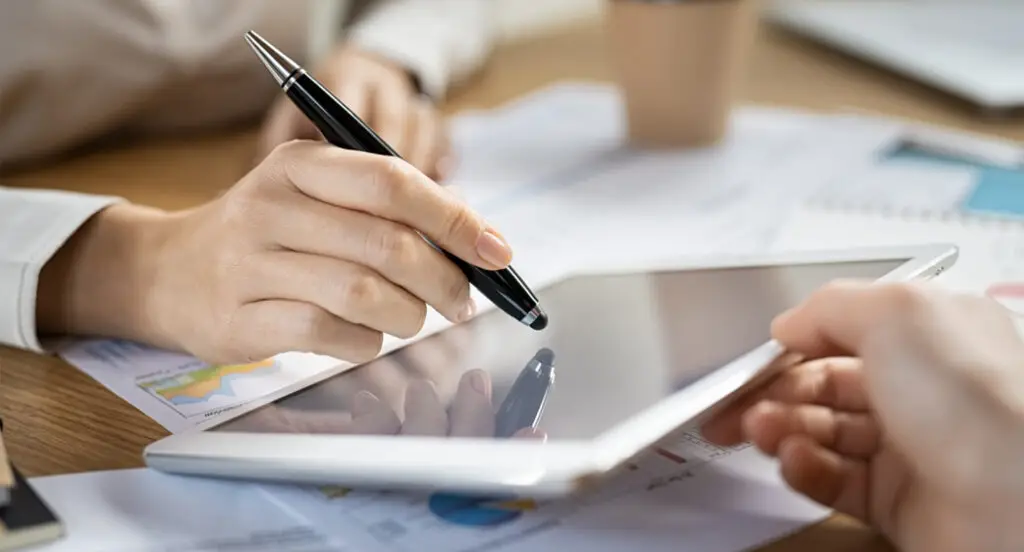 Two people using tablet device with stylus